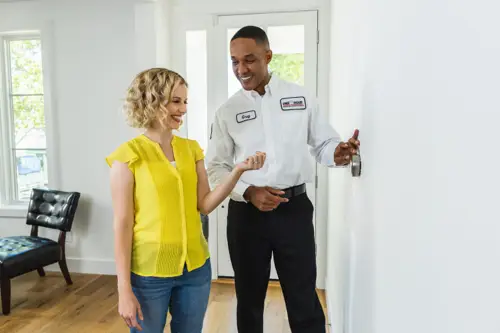 One Hour tech showing homeowner how to calibrate thermostat 